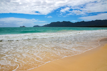 Receding waves under dense clouds at Bellows Beach, Oahu, Hawaii