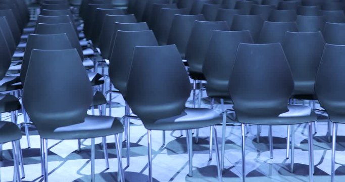 large Empty conference hall with rows of seats for spectators and audience.