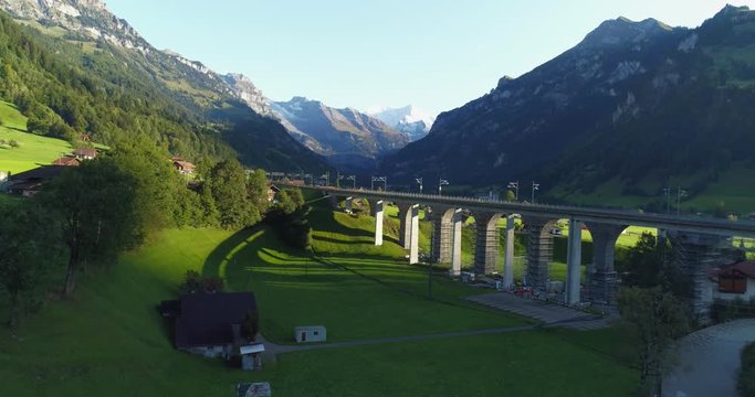 Automotive and railway aqueduct in alpine foothill in Switzerland. Scenic peaceful view of countryside life. Top view of traditional swiss beautiful village. Vacation and european destination concept