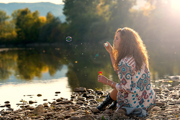 Beautiful girl makes bubbles of soap