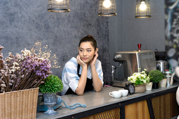 asian woman standing in counter of coffee shop barista