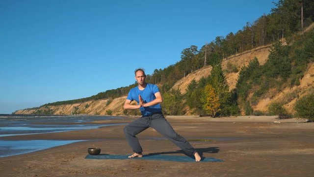 Athletic muscular young man working out, yoga, goddess, sumo wrestler pose
