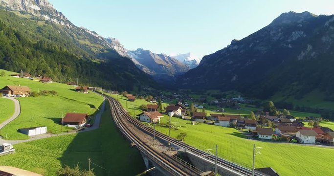 Amazing railroad aerial view alpine foothill in Switzerland. Scenic peaceful view of countryside life. Top view of traditional swiss beautiful village. Vacation, european destination concept