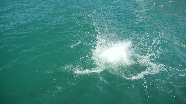 the man dives off the pier in the sea. 4k, slow motion
