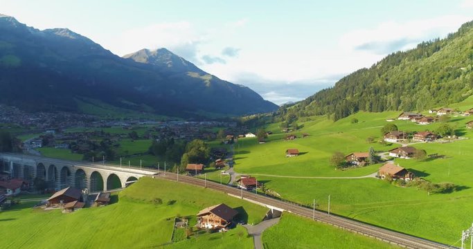 Amazing railroad aerial view alpine foothill in Switzerland. Scenic peaceful view of countryside life. Top view of traditional swiss beautiful village. Vacation, european destination concept