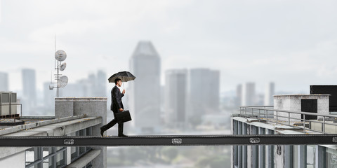 Fearless businessman overcoming difficulty. Mixed media