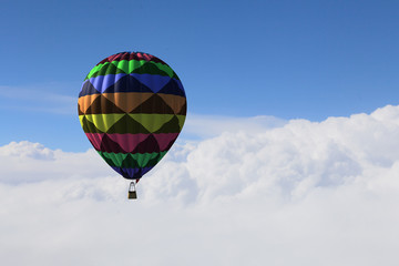 Aerostat floating in day sky. Mixed media