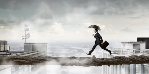 Fearless businessman overcoming difficulty. Mixed media