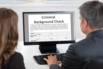 Two Businesspeople Looking At Calendar On Computer