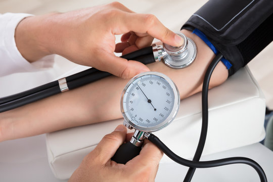 Doctor Checking Blood Pressure Of Patient