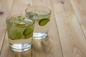 Detox water with cucumber and lemon on wooden table. Cucumber lemonade