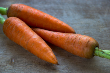 Young fresh carrots on wooden background. Organic natural food