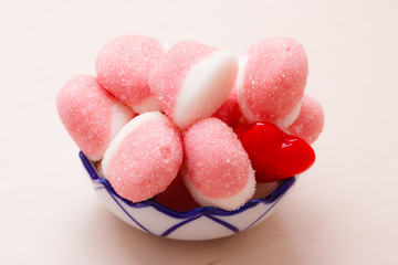 Pink jellies or marshmallows with sugar in bowl