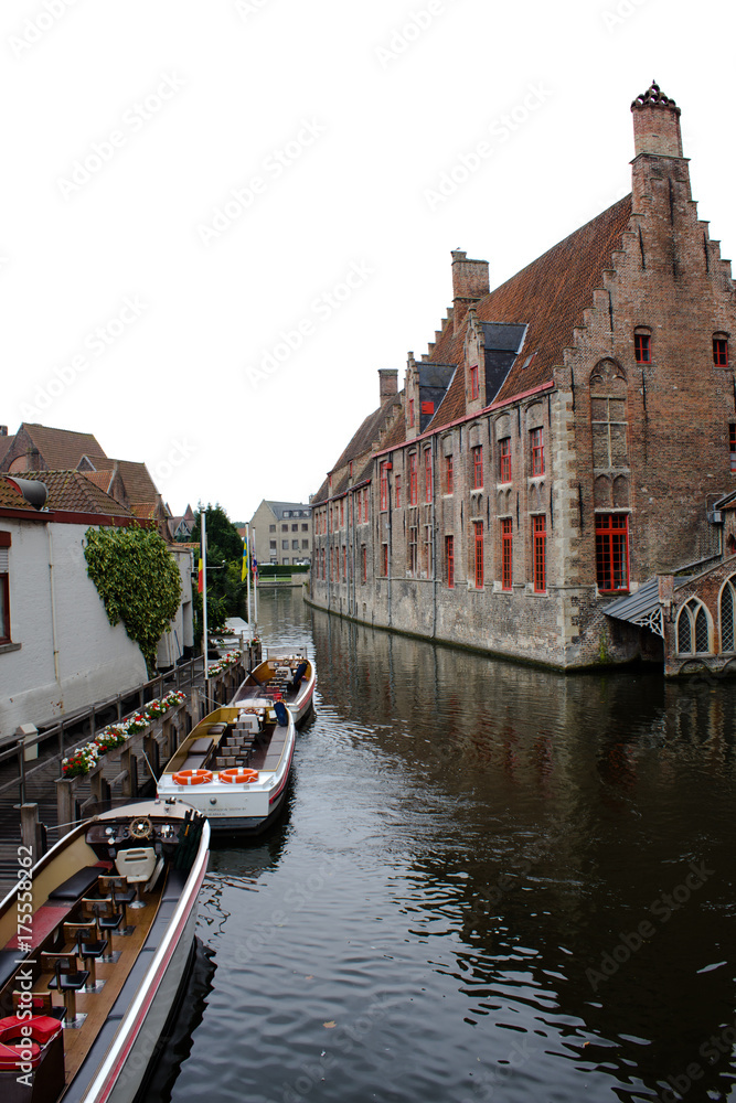 Wall mural sightseeing boat on bruges canal and building architecture and landmark of bruges belgium