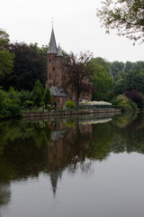 Fototapeta na wymiar Gothic style building at Lake of Love, Minnewater Park, Bruges Belgium