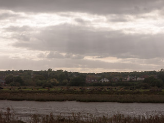 overcast dramatic grey storm clouds above river through country land