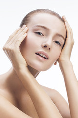 Close-up beauty shot of a beautiful young blonde women with sensuality in the eyes. 
Focus on face and nice shiny skin. 
