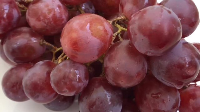 A lot Red Grapes White background wet water droplet, authentic motion rain water droplets natural fruti