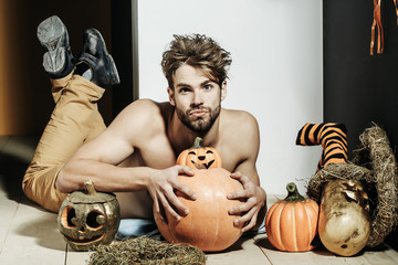 Halloween man with bared torso lying on floor