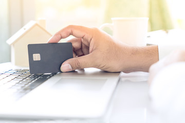 Businessman use credit card to shopping online in internet website shop with computer laptop on work table with a cup of coffee