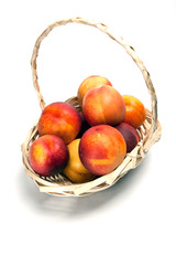 Basket full of fresh peaches isolated on white background