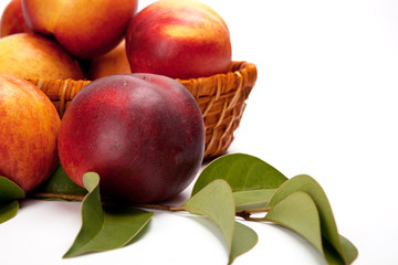 Fresh fruit nectarines in the basket, on white background