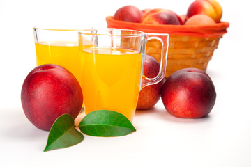 two glasses of juice and fresh peaches  on white background