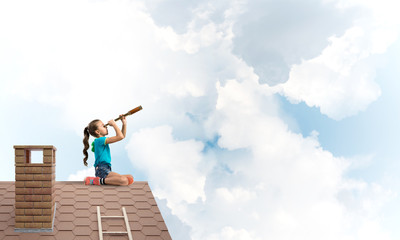 Concept of careless happy childhood with girl looking in spyglass