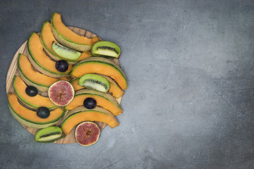 Top view on different kind of fruits arranged on wooden board with copyspace.