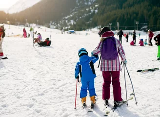 Foto op Aluminium Rear view of little skiers first steps to learning ski. © dusanpetkovic1