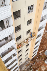 The painter works on the lift of a new building