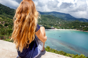 Fototapeta na wymiar Young beautiful woman with long blonde flying hair, travel concept, sea view point