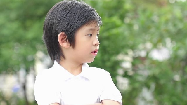 Close up of sad and unhappy child in the park slow motion 