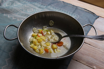 Macaroni soup with vegetables. Pasta soup in metal bowl.