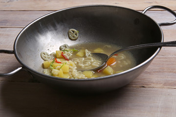 Macaroni soup with vegetables. Pasta soup in metal bowl.