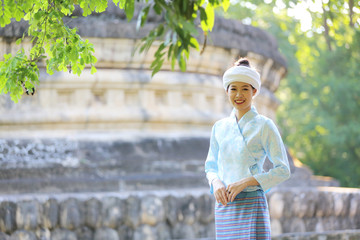 Thai woman wearing traditional Thai dress with old temple background