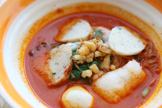Fish and fishball Tom yum noodle on wood background , Thai food