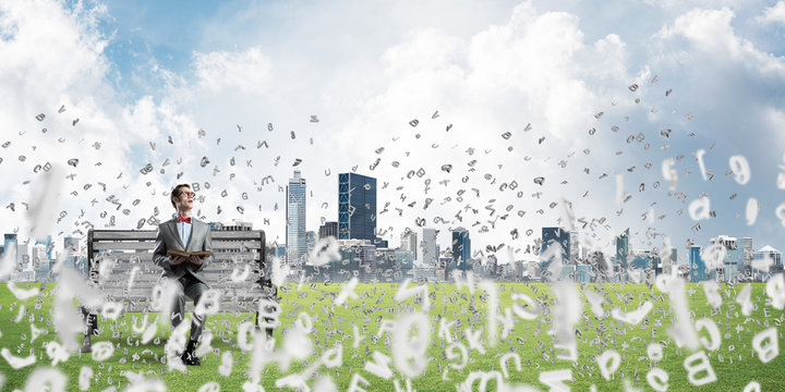 Young businessman or student studying the science and symbols fly around