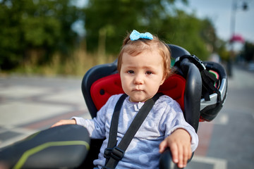 girl sitting in a baby bike seat of a bicycle of her father safety emotions anxiety kids children parenting.