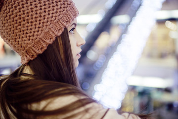 girl in a knitted hat walking in the mall