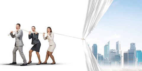 Young businesspeople working in collaboration and pulling white advertisement banner