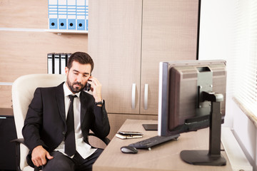 Businessman talking on the phone and working in the office. Businessperson in professional environment