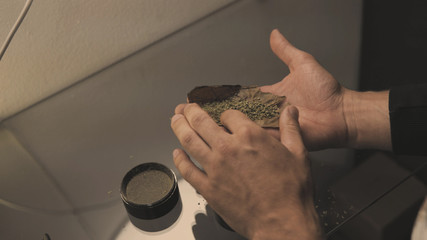Roll a weed buds blunt in man hands close-up. twisting  jointwith the buds of marijuana inside.