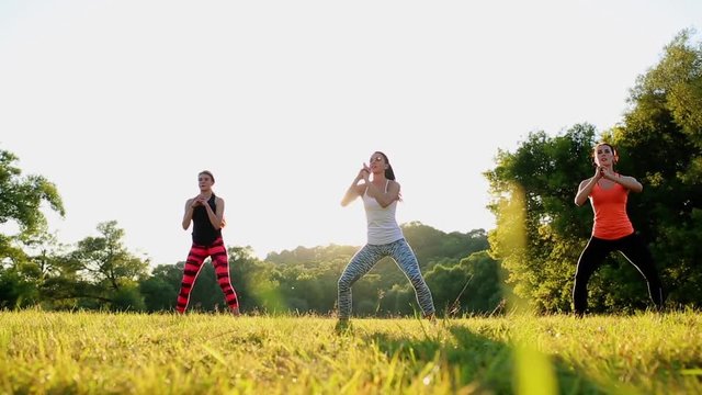 group of young people having kick boxing training , outdoor