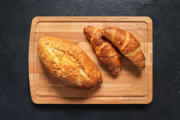 Homemade bread and croissants on a cutting board. The view from the top.