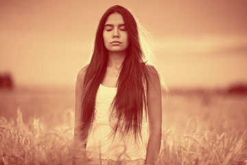 Naklejka premium Sad lonely young girl in a field bored with depression