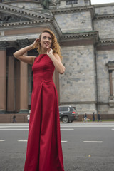Beautiful elegant woman in a red dress on the street