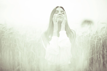 Fototapeta premium Young glamorous model posing in a field wheat