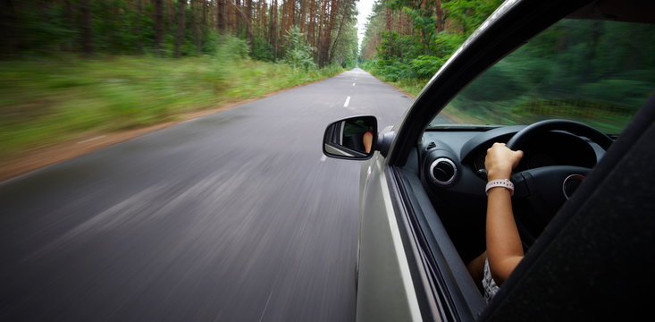 Young beautiful woman driving car - rear view
