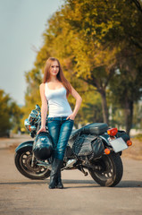 Fototapeta na wymiar Beautiful young girl near the motorbike